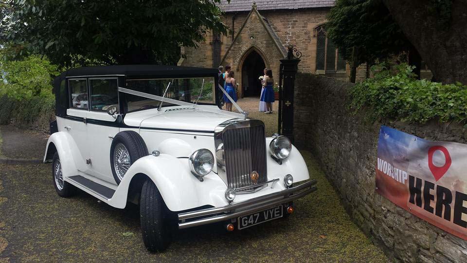 Regent Convertible decorated with reibbons parked in front of a church