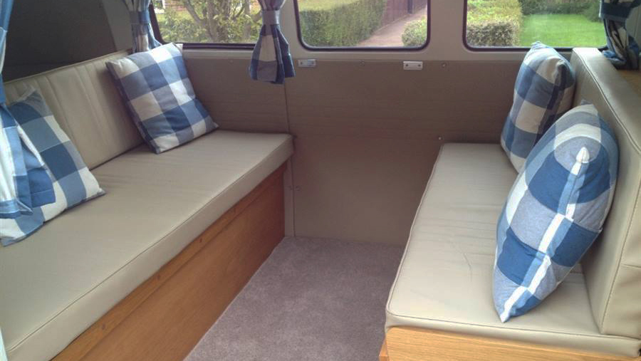 Classic VW Campervan rear interior cream seats decorated with white and blue cushions