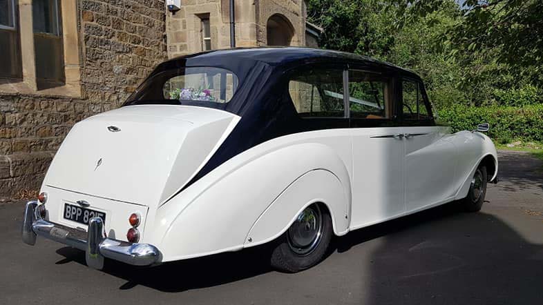 Right rear view of Ivory Austin Princess Limousine with Black Roof and chrome rear bumper