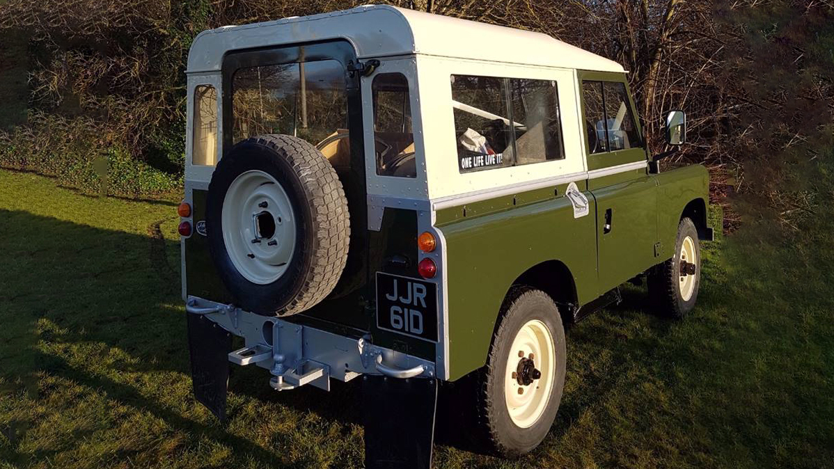 Rear view of Classic Landrover with spare week mounted at the back of the vehicle.