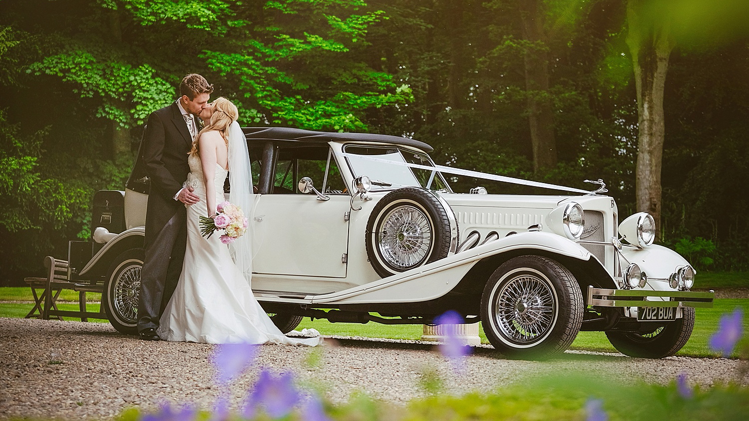 Beauford Convertible with Bride and Groom kissing next to the vehicle.