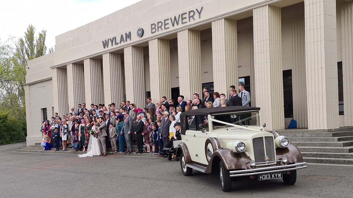 Vintage Regent Convertible in front of Wylam Brewary in Newcastle with wedding party all cheering and posing for a group photos.