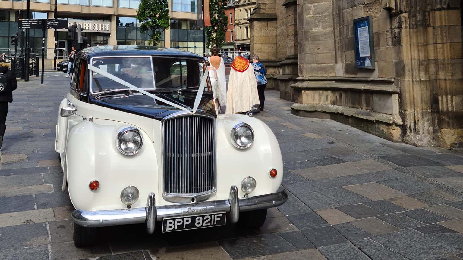 Ivory and Black Austin Princess decorated with ribbons parked in the city of Newcastle