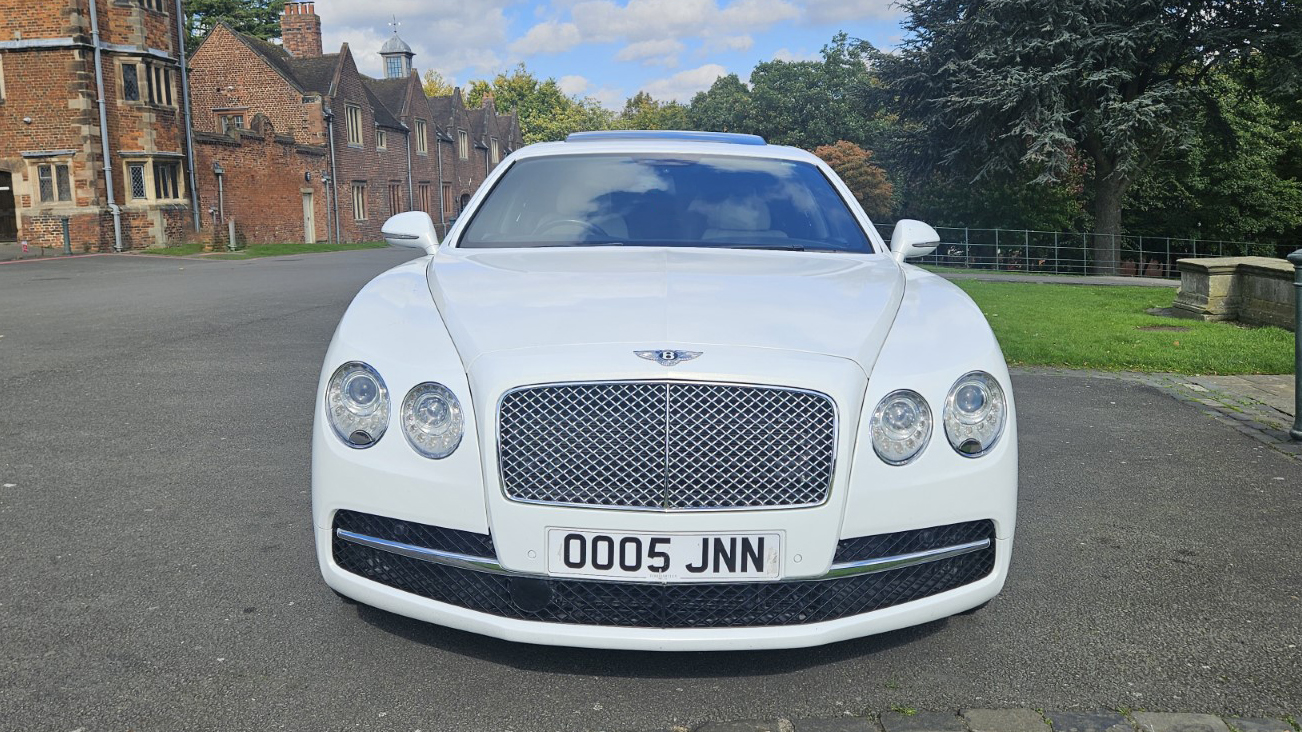 Full front view of White Bentley Flying spur with chrome grill and twin headlights