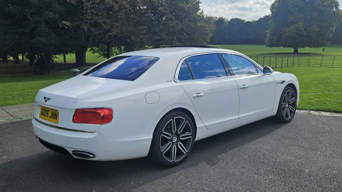 Right right side view of White modern Bentley with tinted rear windows