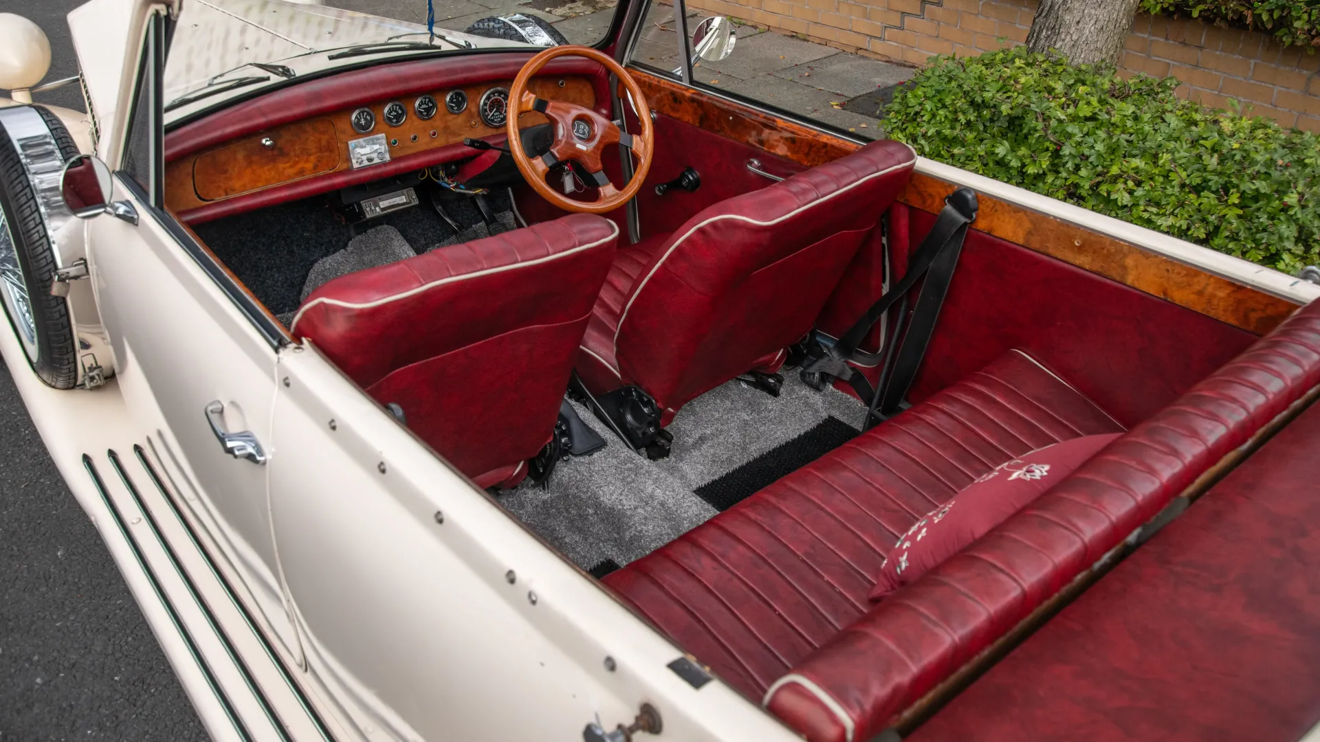 Aerial view of Burgundy leather inside a Beaurford showing wooden steering wheel and plenty of rear passenger legroom