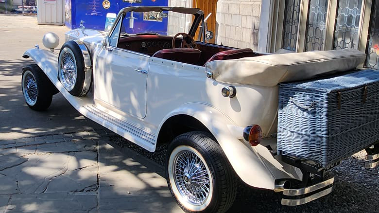 Rear view of Beauford with roof down showing the grey picnic trunk and Burgundy leather seat