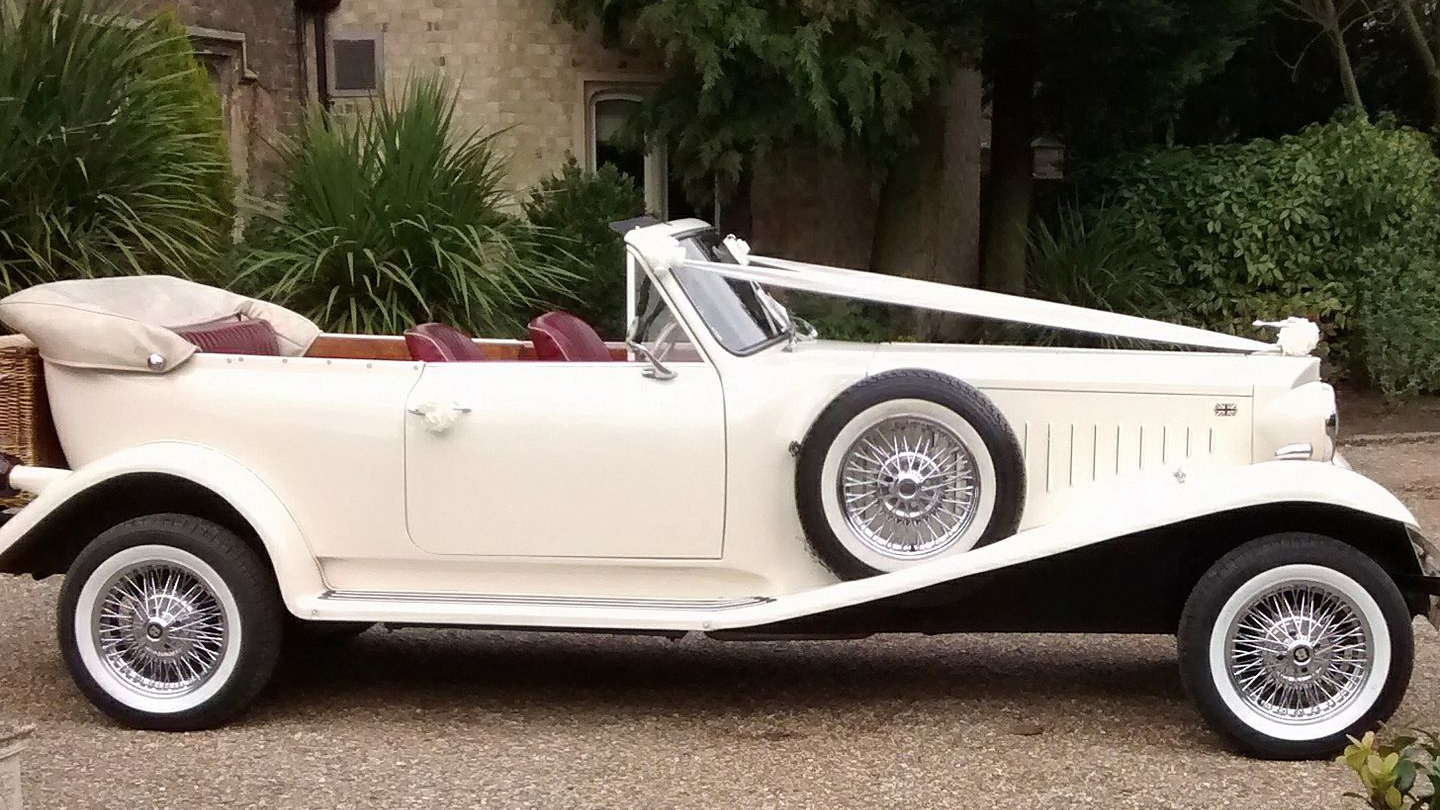 Right side view of vintage Beauford dressed with white ribbons accros its bonnet.