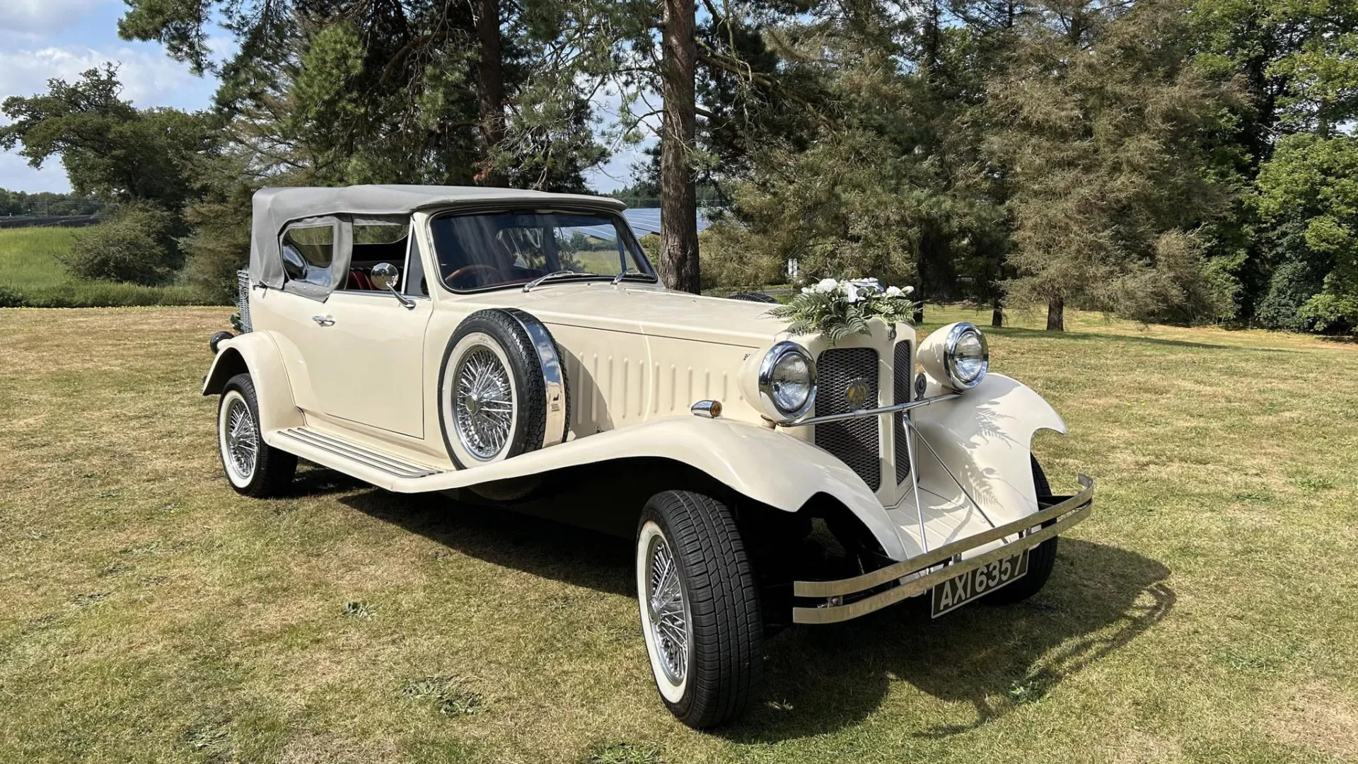 Front right view of Ivory vintage Beauford with spare wheel mounted on the side of the car