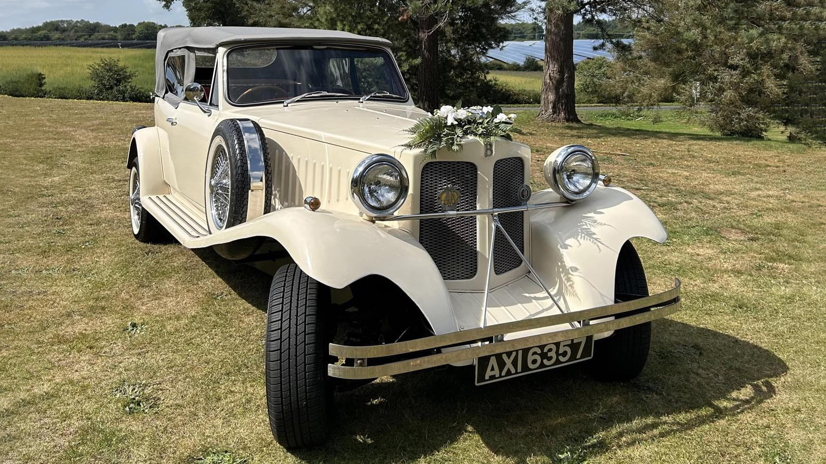 Front view of Ivory BEauford with convertible roof closed. Weddiong flower arrangement on top of its front grill at the end of the bonnet.