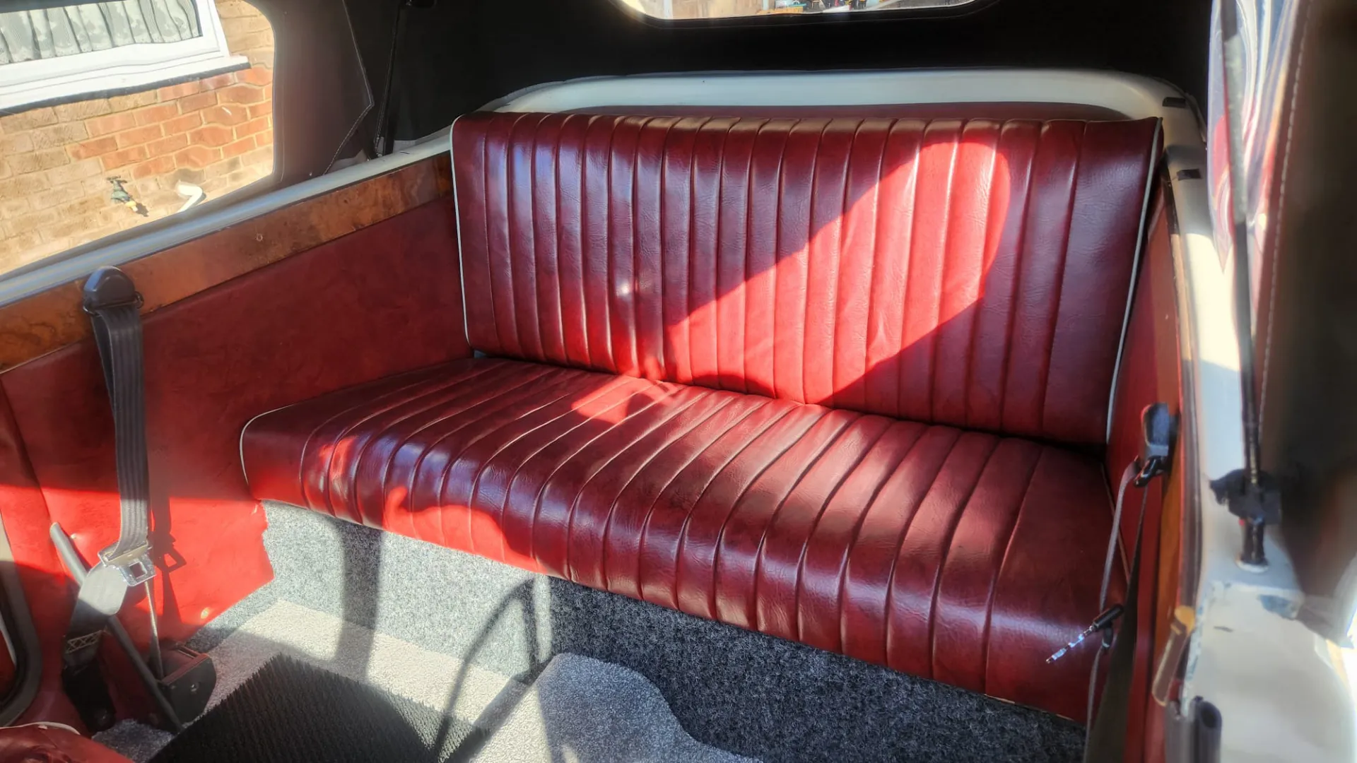 rear interior bench seat in Burgundy inside Beauford convertible.