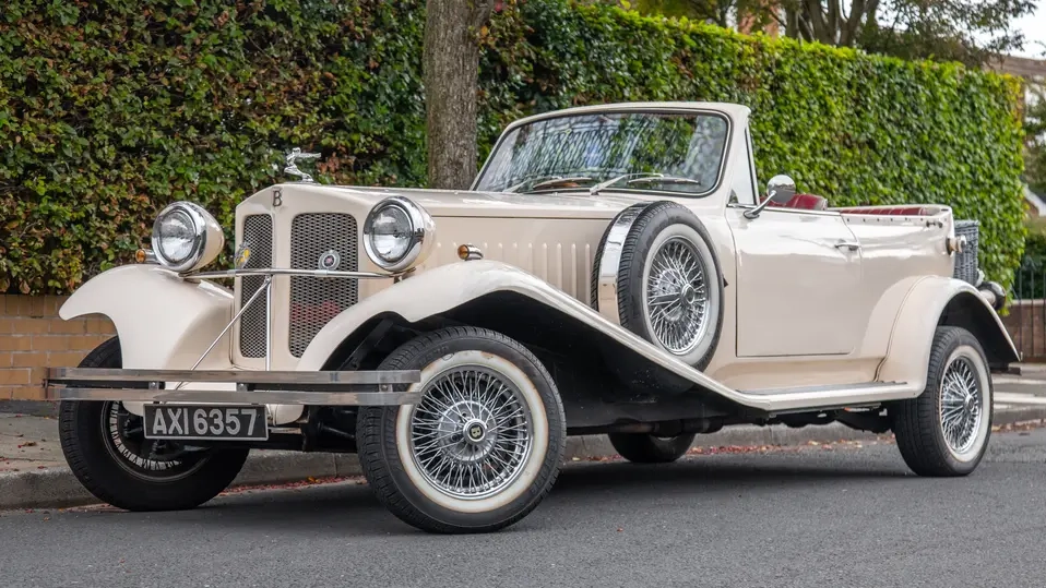 Front side view of Ivory Beauford with Convertible roof down. Spare wheel mounted on the side of the vehicle