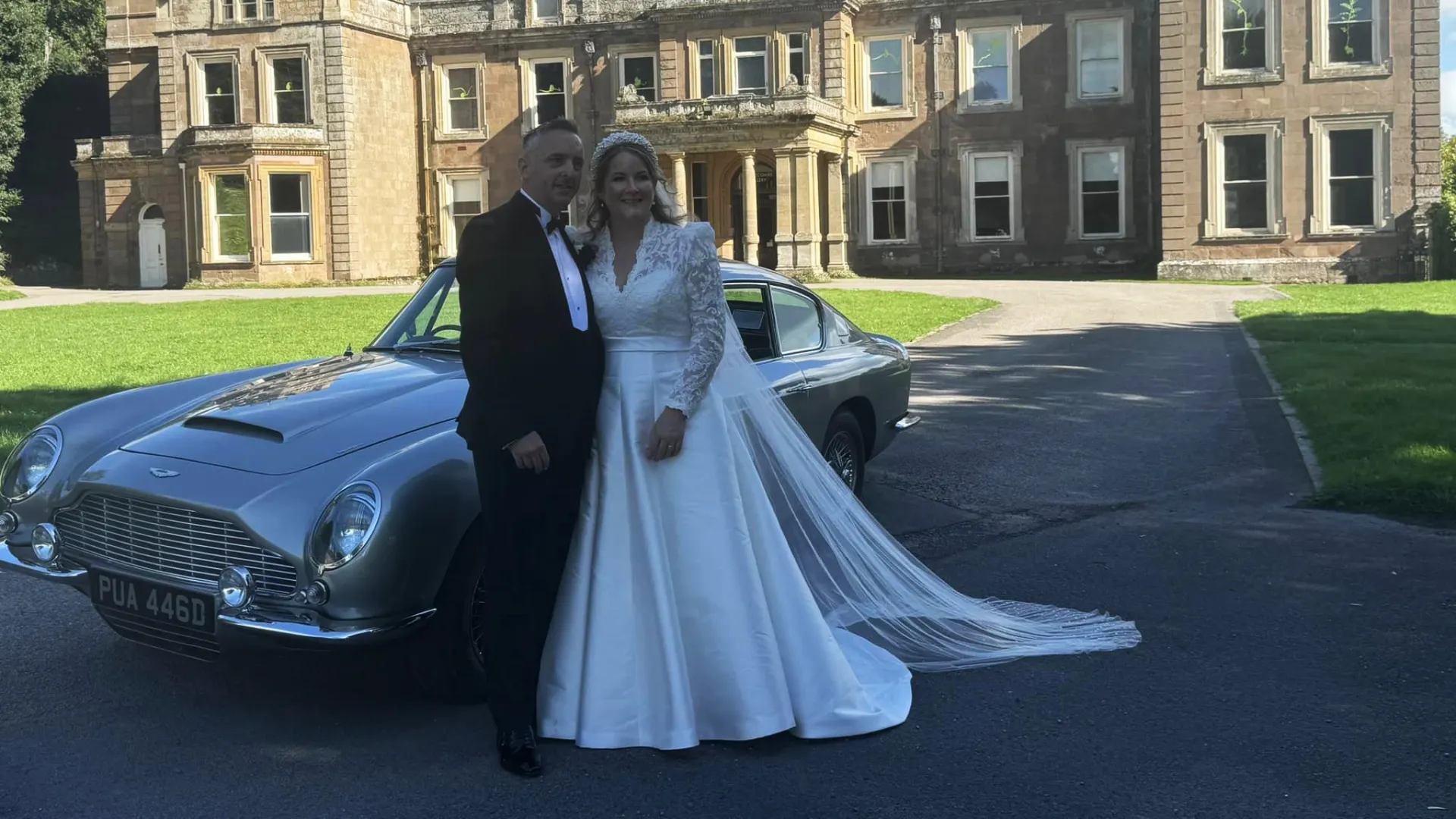 Bride and Groom standing next to Aston Martin DB6