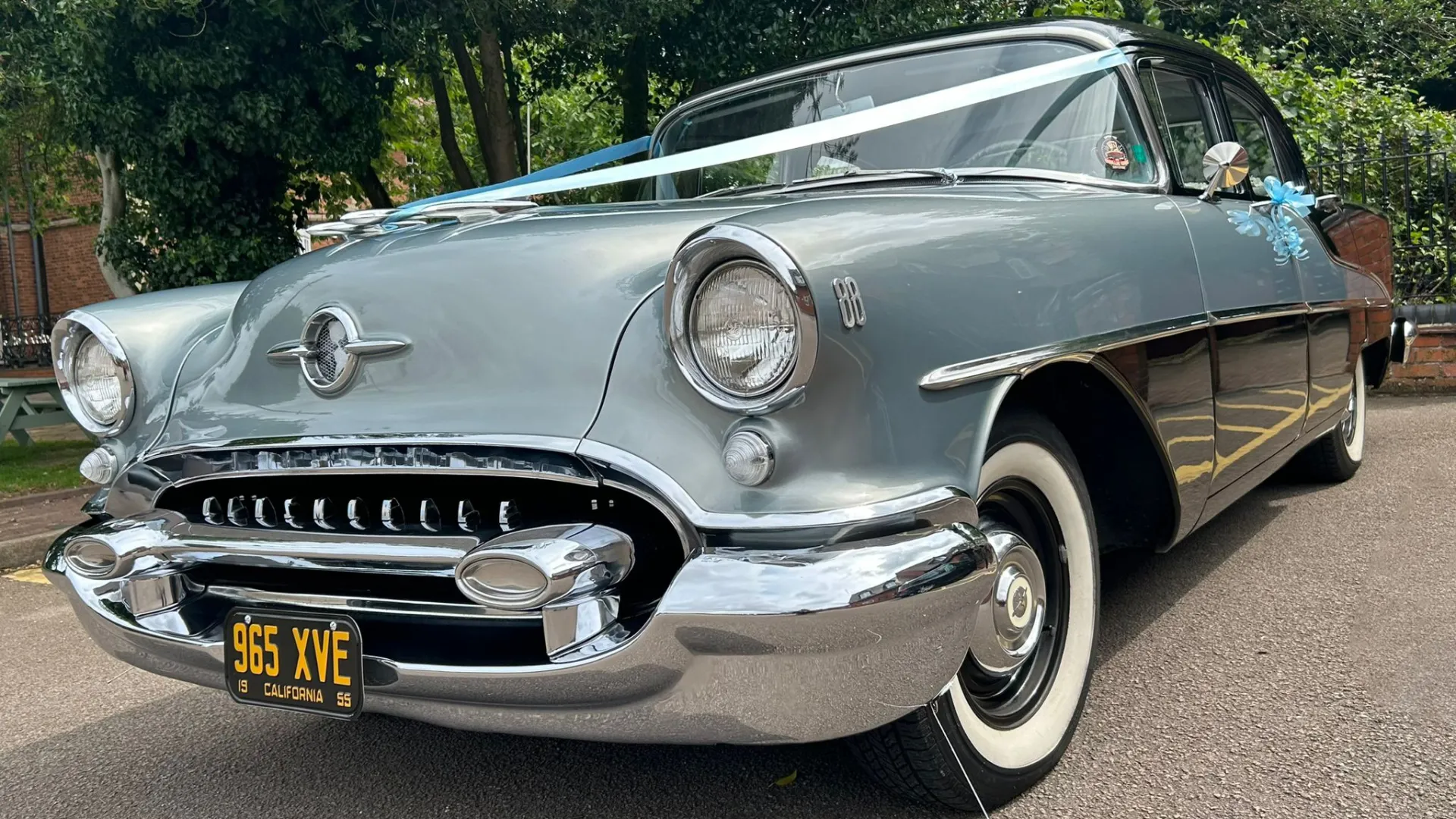 front view classic American Oldsmobile Rocket 88 with white wedding ribbons