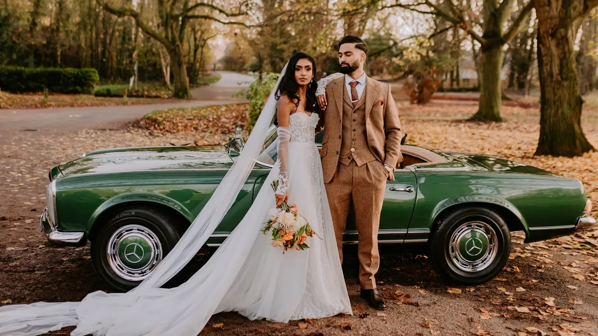 Bride and Groom standing in front of a Classic Mercedes Convertible in Aqua Green with Autumn Background