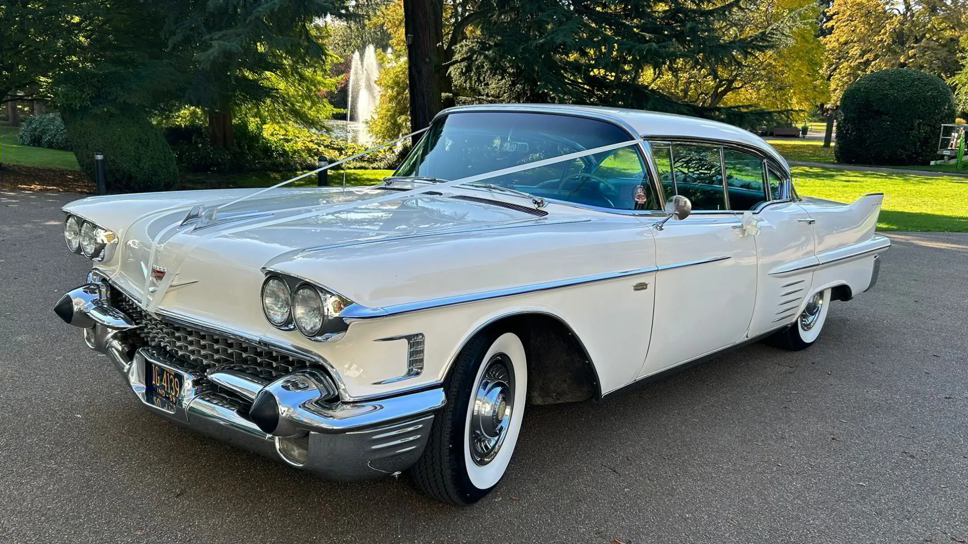 Front left view of a White american Cadilalc decorated with white ribbons