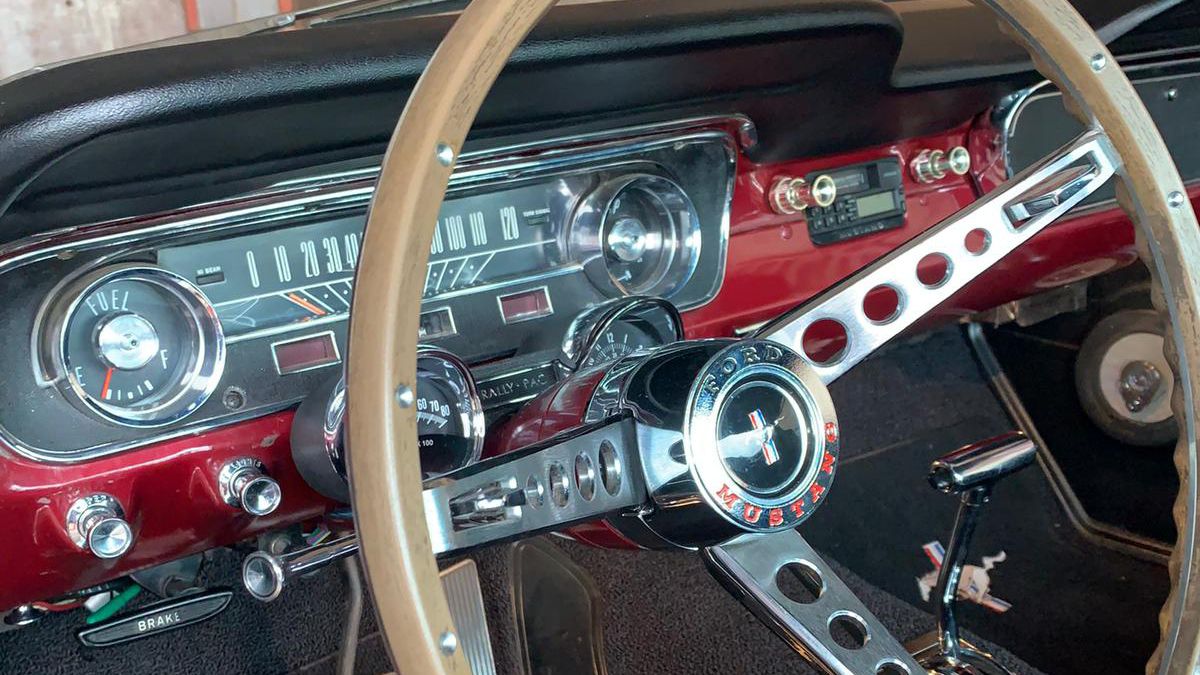 Front dashboard and wooden steering wheel inside classic Ford Mustang