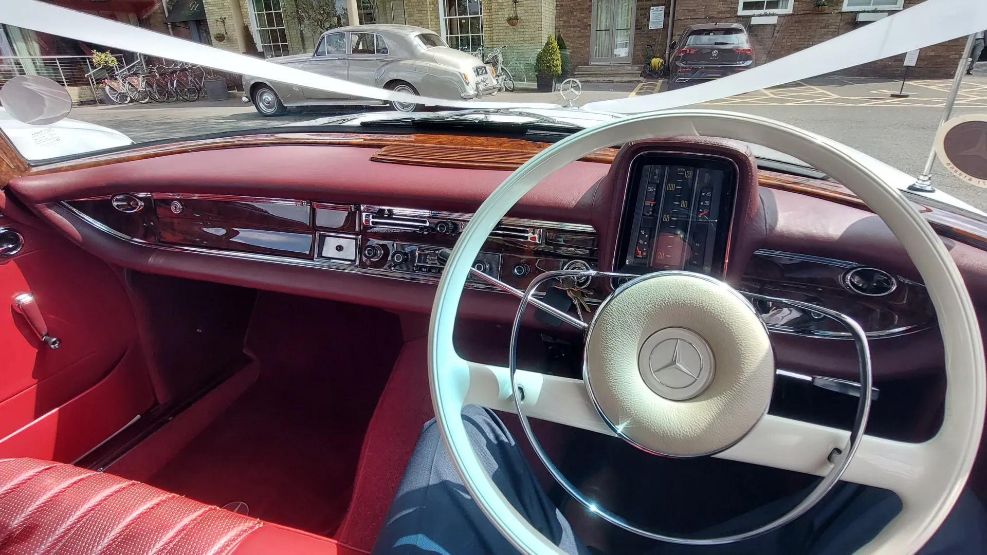 Front driver dashboard inside Classic Mercedes. Burgundy leather seats and Burgundy Dashboard.