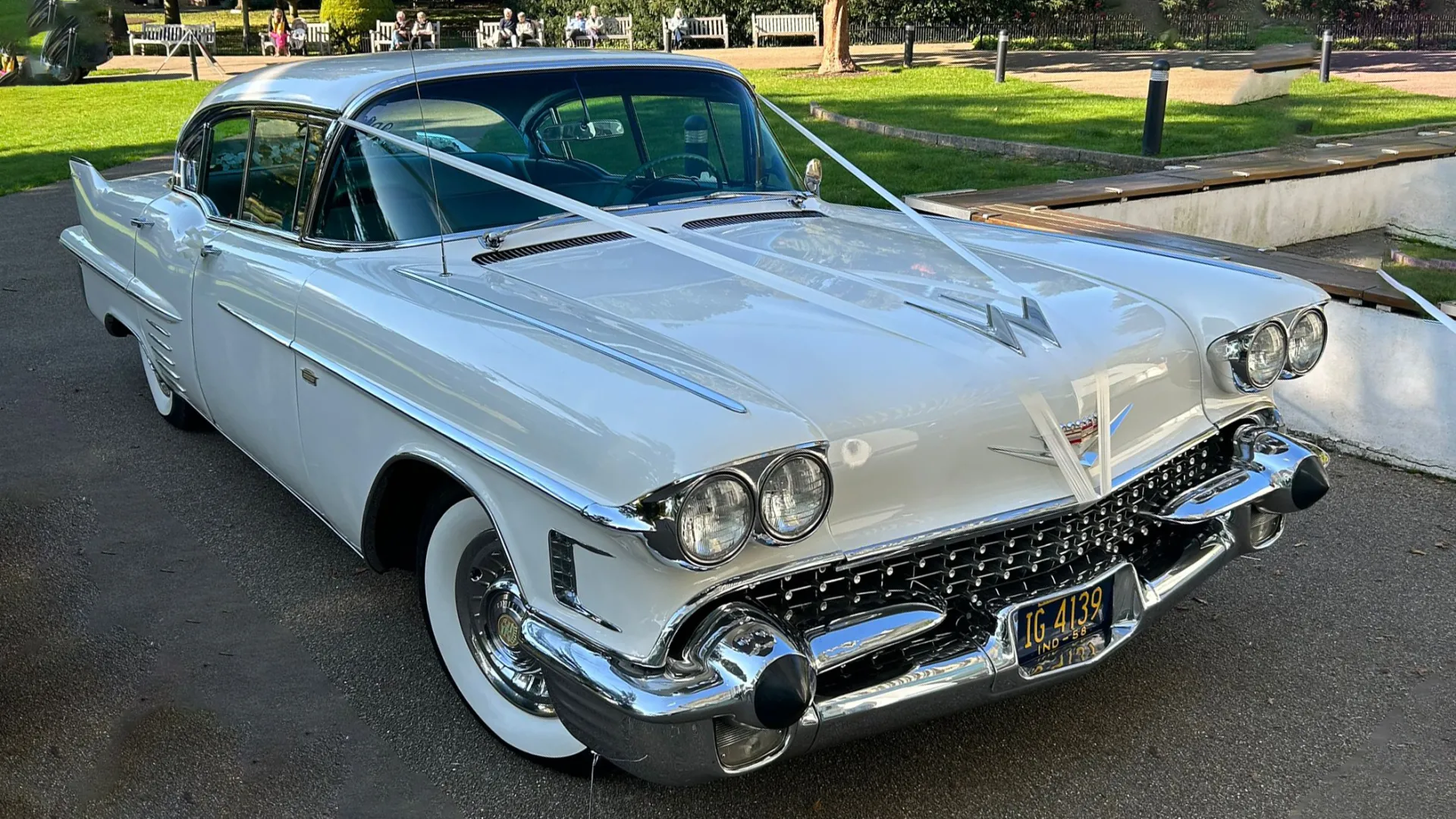 Classic White American Wedding Car with white wedding ribbons and large white wall tires.