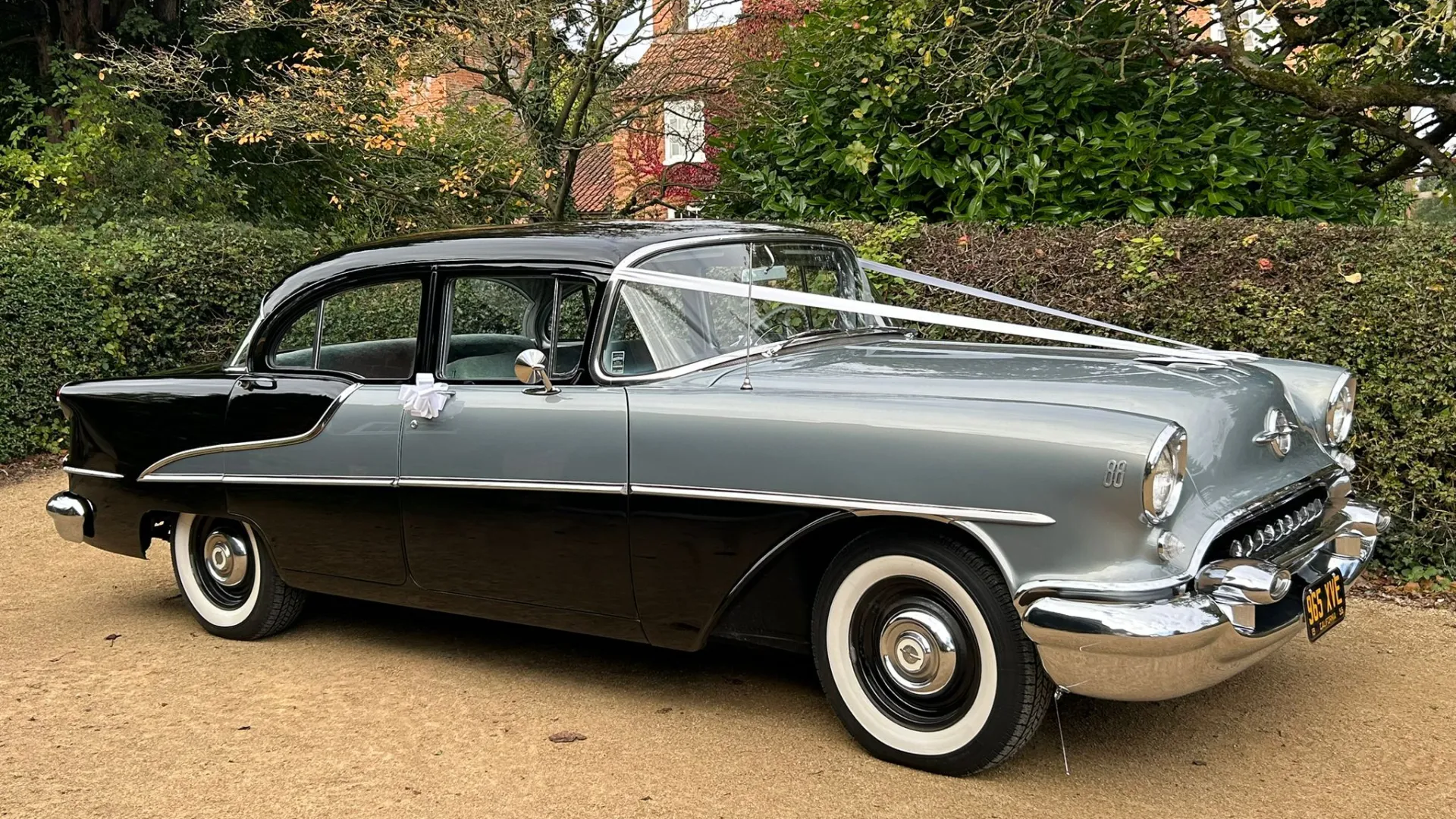 Classic American Oldsmobile Rocket 88 in Black and Silver decorated with white ribbons