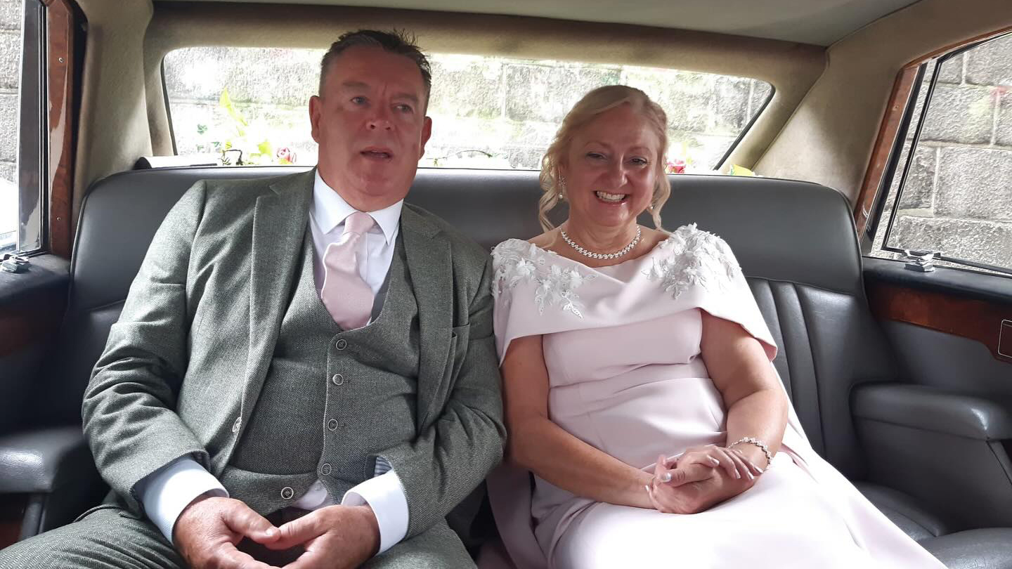 Bride and Groom seating inside the Daimler Ds420 Limousine smiling