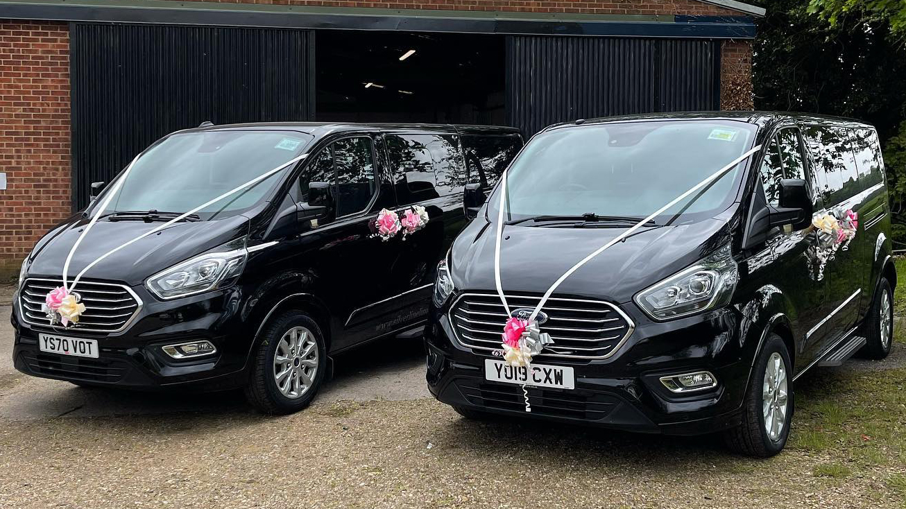 Two identical Black Ford Mini Bus