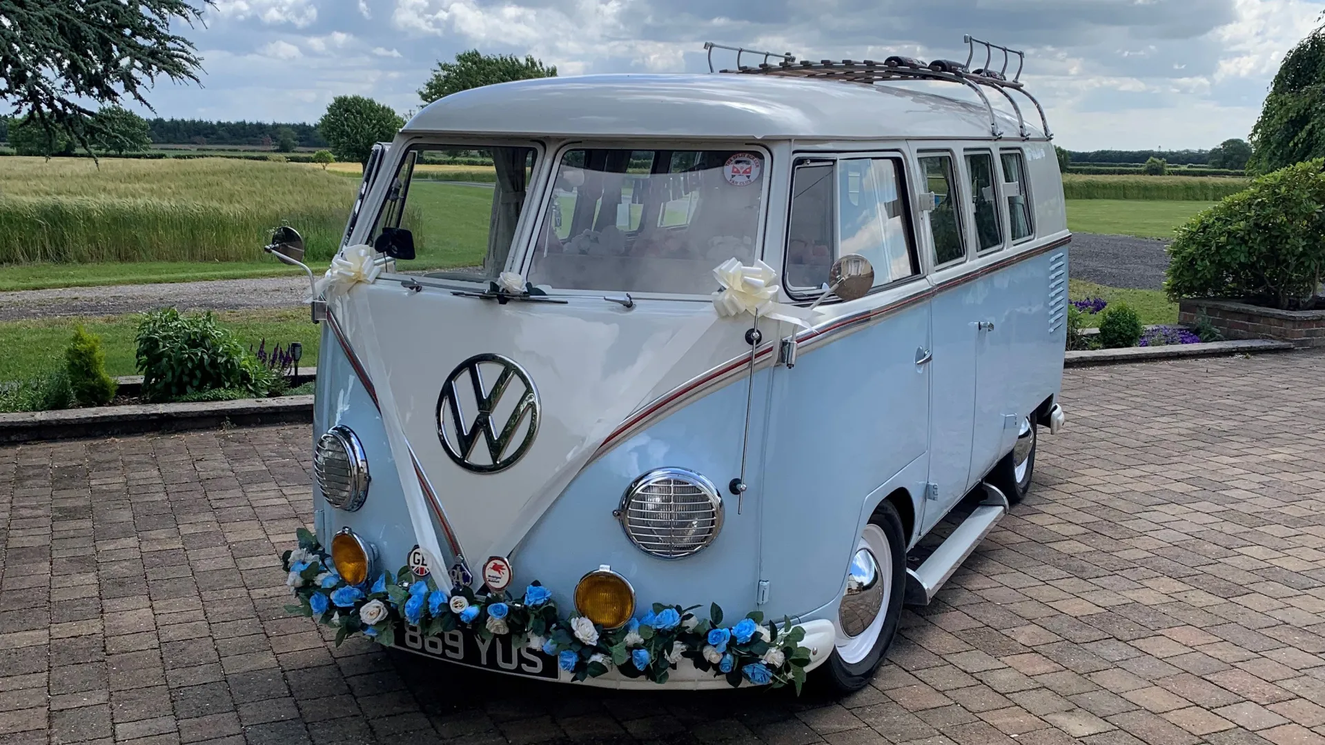 Skye Blue and White Classic VW Campervan decorated with blue flowers on front bumper and Ivory Wedding Ribbons and Bows