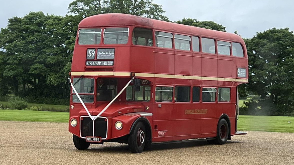 Red Routemaster Wedding bus with White Ribbons across front