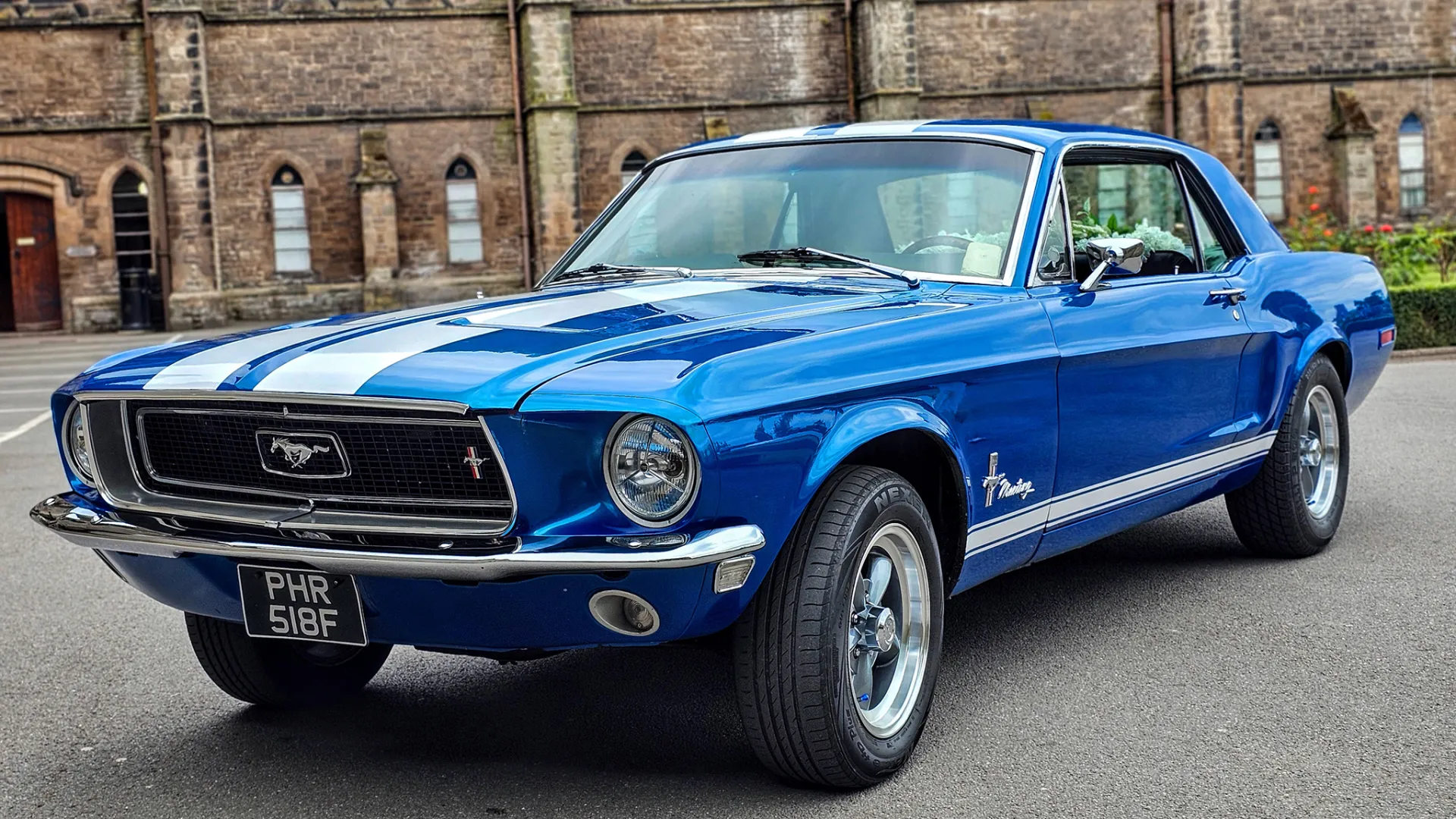 Classic Blue Ford Mustang left view. Parked in front of a wedding venue