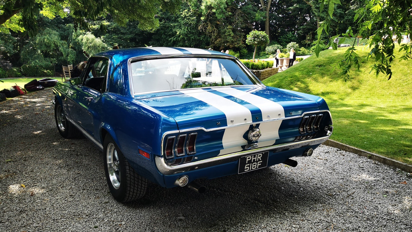 Rear view of Classic Blue Ford Mustang with chrome bumper and chrome features around the rear lights