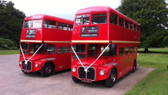 Two identical Red Routemaster Wedding buses with matching white ribbons