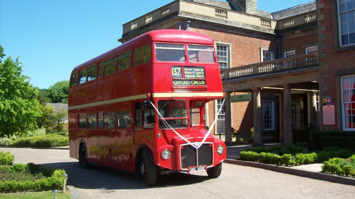 Double Decker Routemaster Red Bus decorated with white ribbons