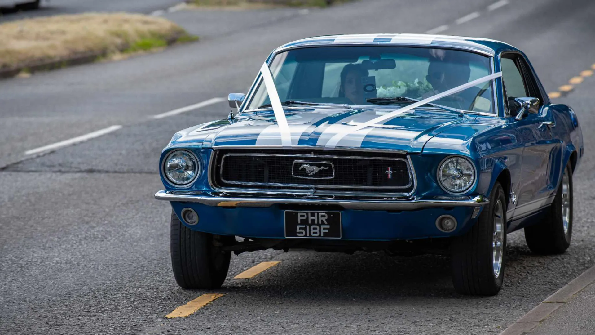 Classic Blue Ford Mustang with white wedding ribbons