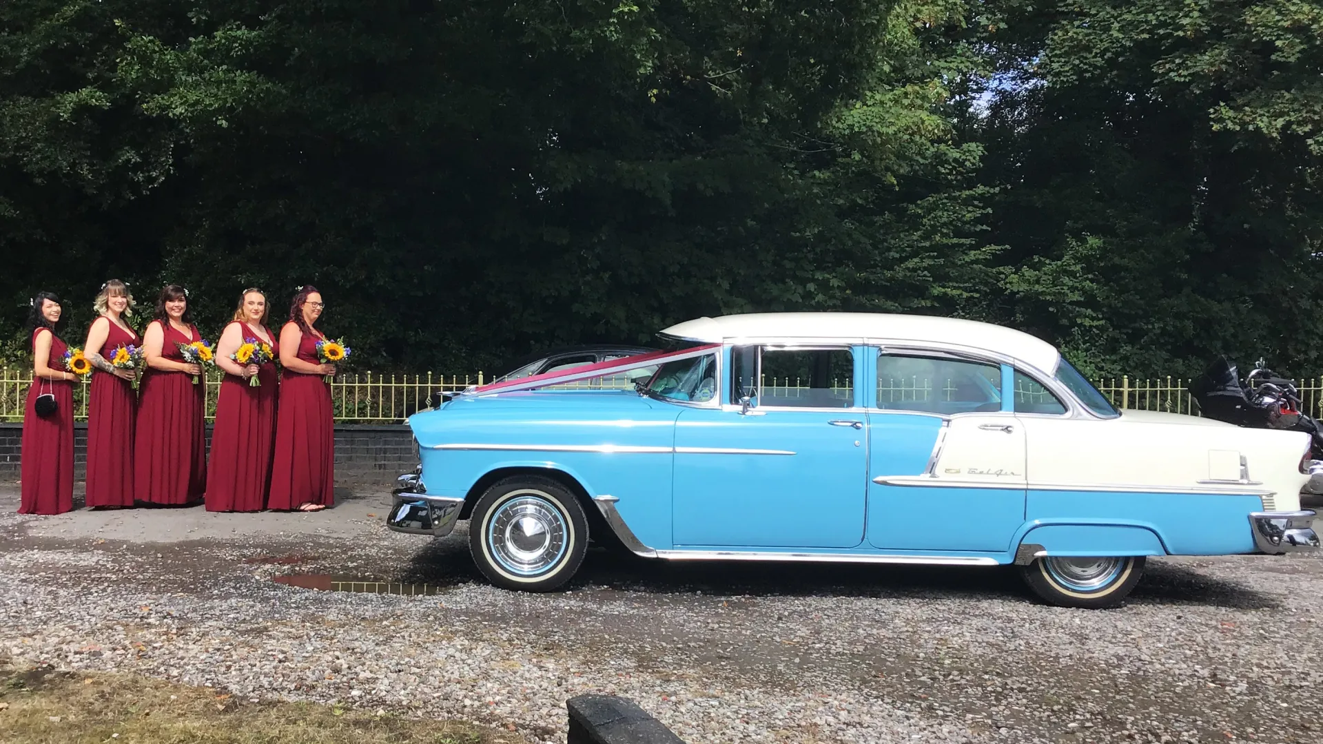 Five Bridemaids wearing matching Burgundy Dresses standing in front of a classic American Chevrolet