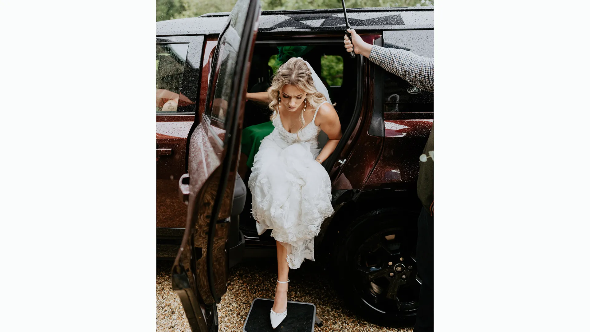 Bride exiting a modern landrover and stepping on a little stool in front of the vehicle