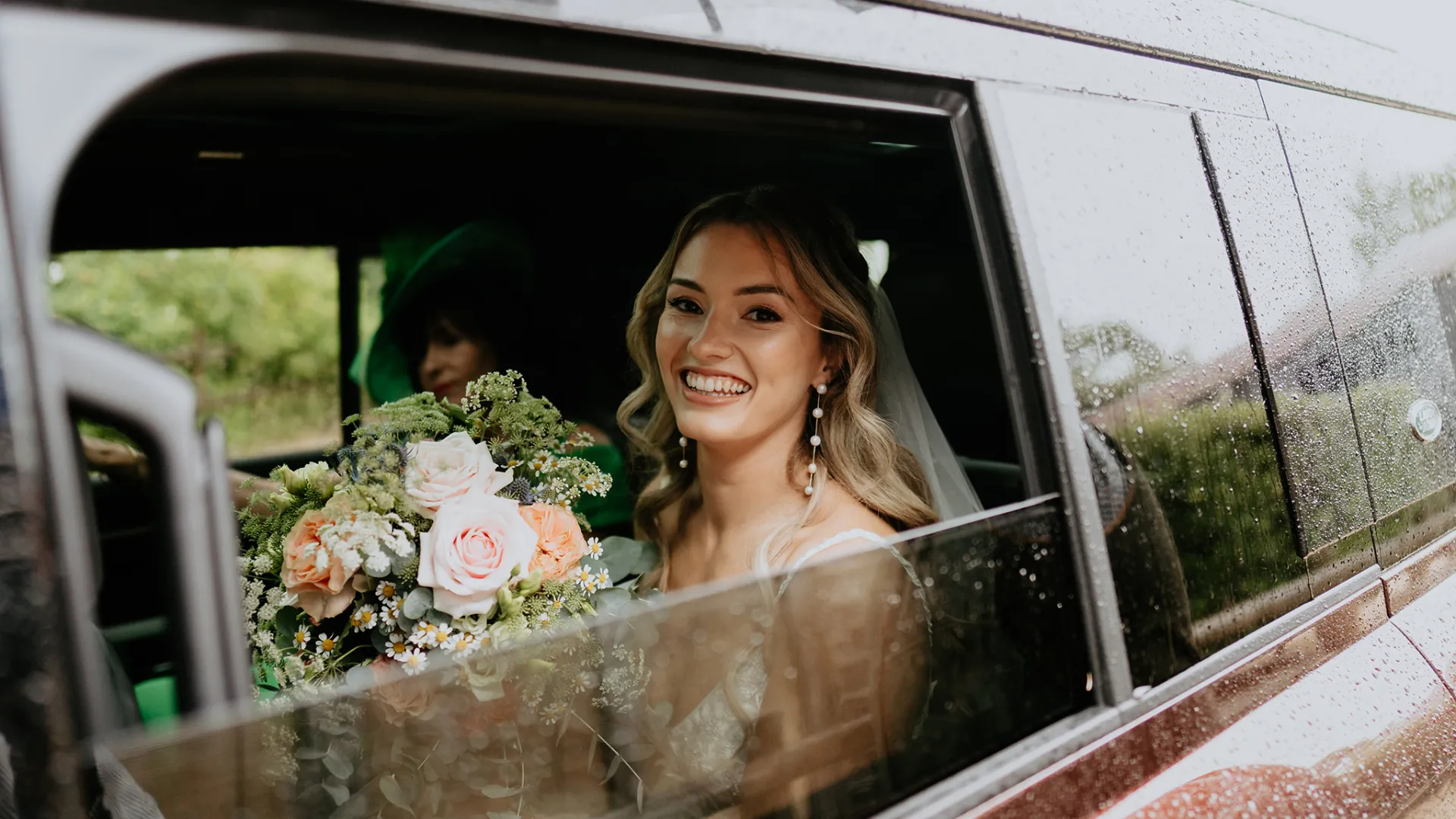 Bride seating inside Modern Landrover smiling through the window