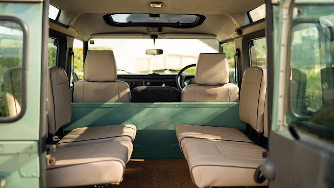 Full inside view of cream leather seats inside green classic landrover defender