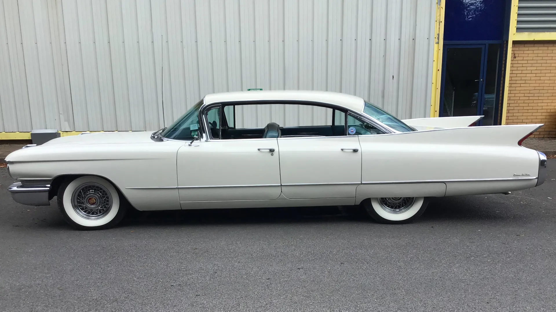 Left side view of white classic american Cadillac with white wall tires