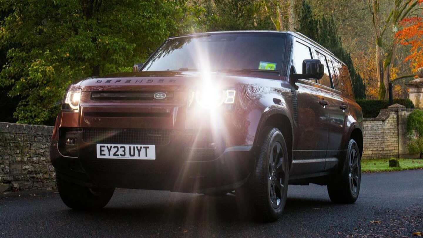 Front view of Land Rover Defender with headlights on