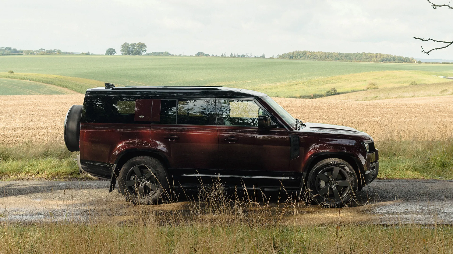 Right Side view of Modern Land Rover Defender 130 in Sedona Red