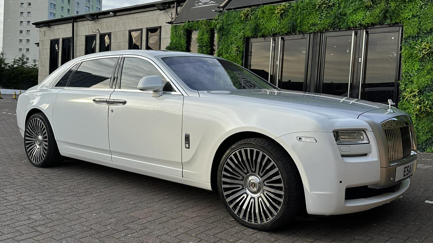 White Rolls-Royce Ghost with large alloy wheels in front of wedding venue in Bradford