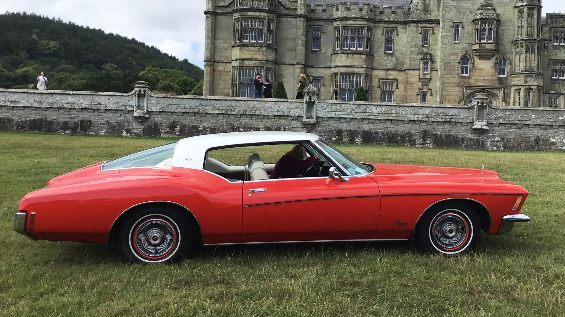 Right side view of classic 2-door Buick Riviera in Red with White Roof.