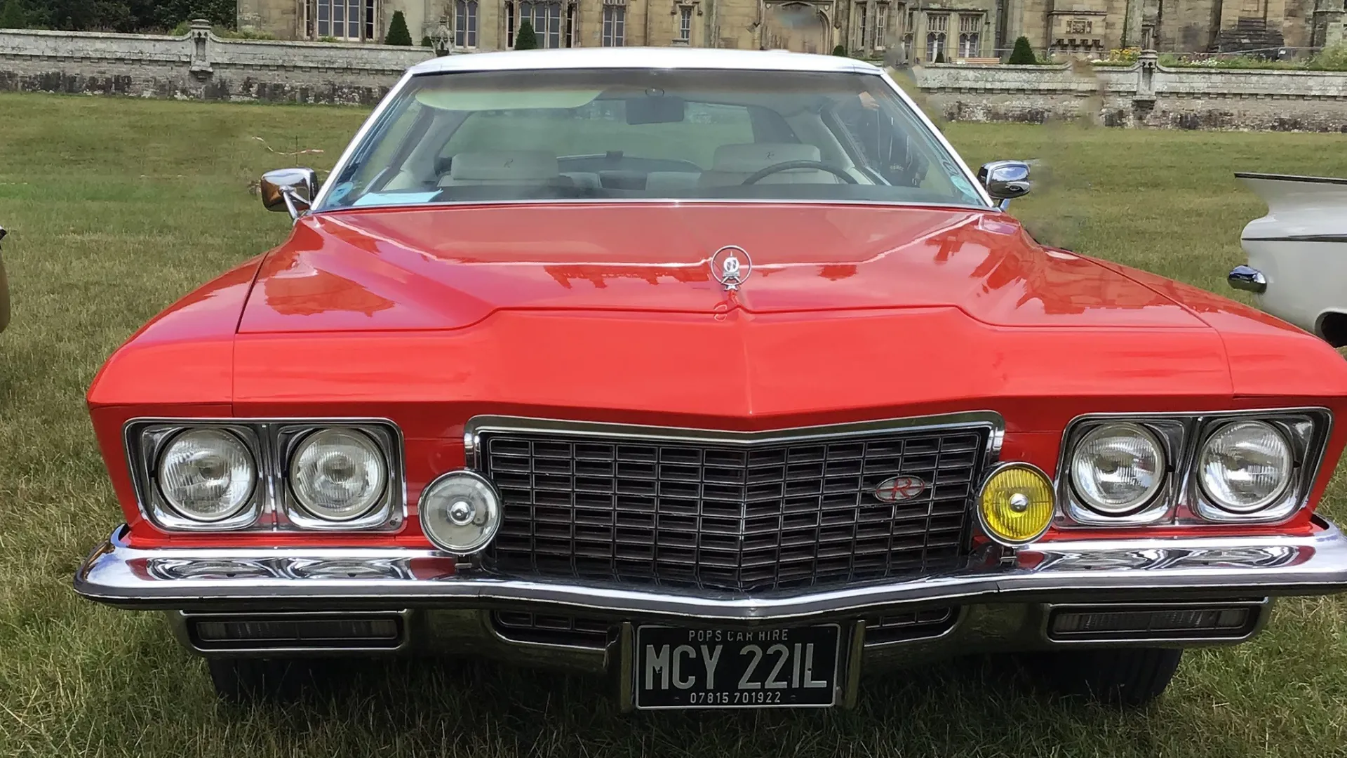 Frotn view of Red Classic Buick with chrome bumpers, twin headlights