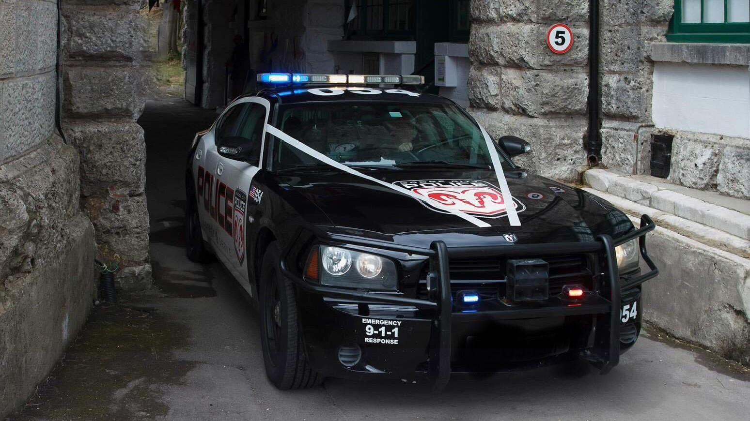 American Police car Dodge Charge Pursuit in Black and White decorated with white wedding ribbons