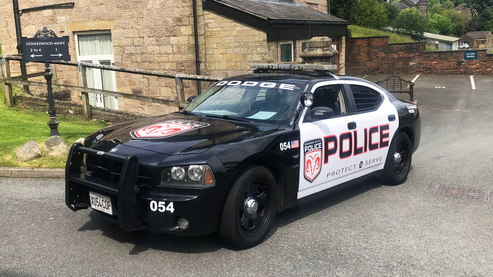 Black and White Dodge Charger Pursuit with Police sign on the side of the door