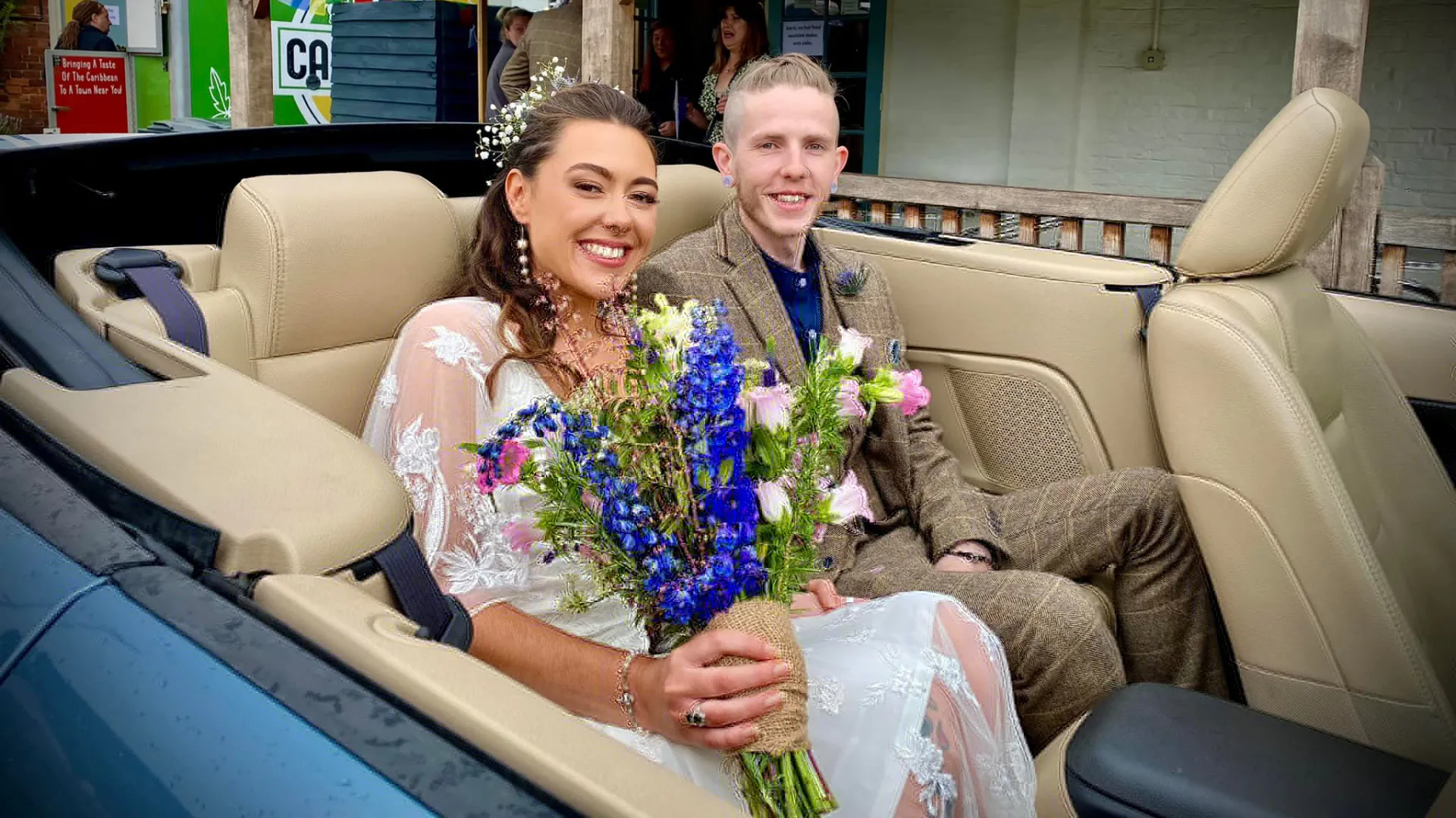 Bride and Groom smiling seating inside Convertible Mustang with Cream leather seats and roof down