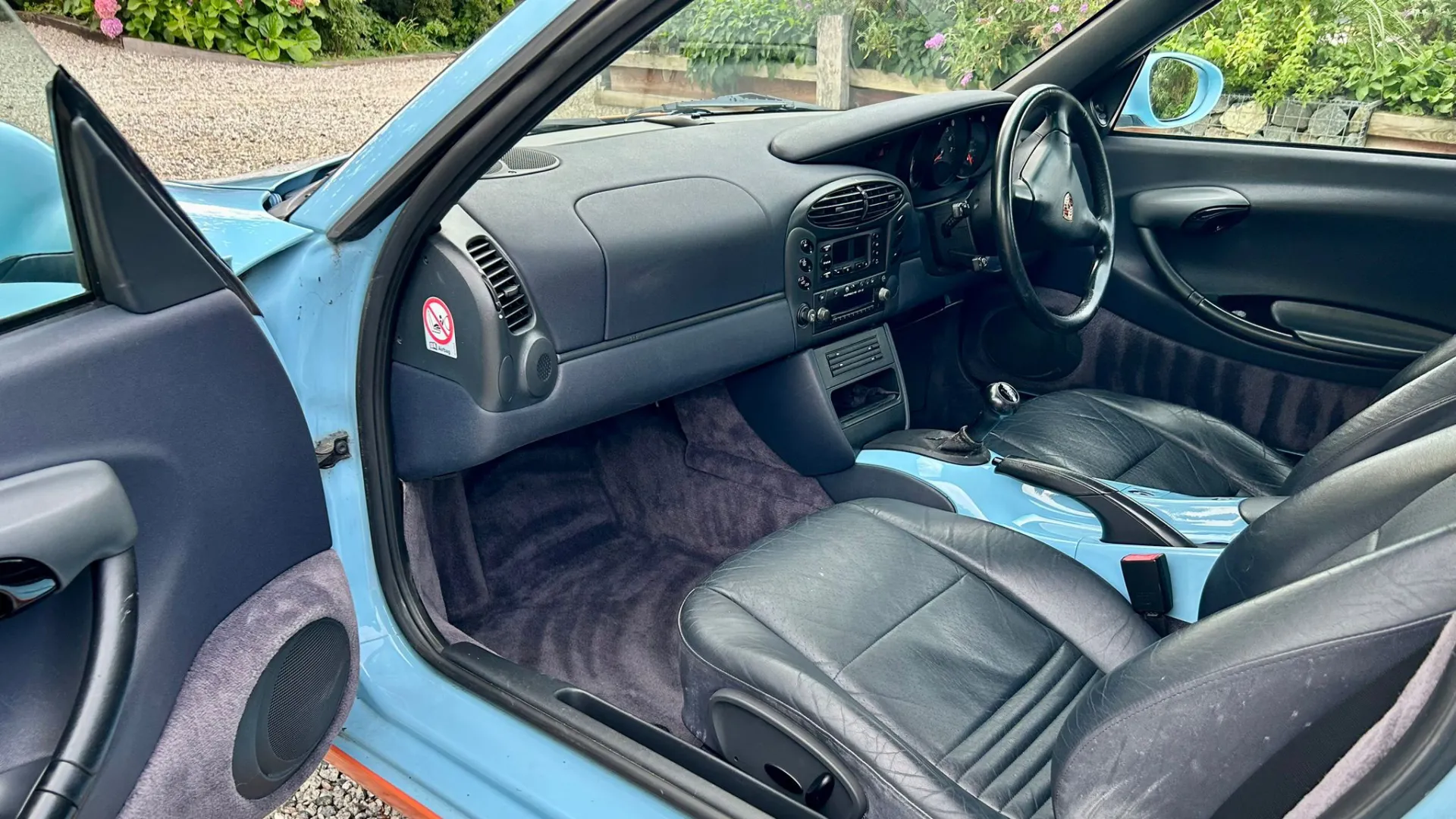 Black leater interior in porsche Boxster with passenger's door open showing space for passenger