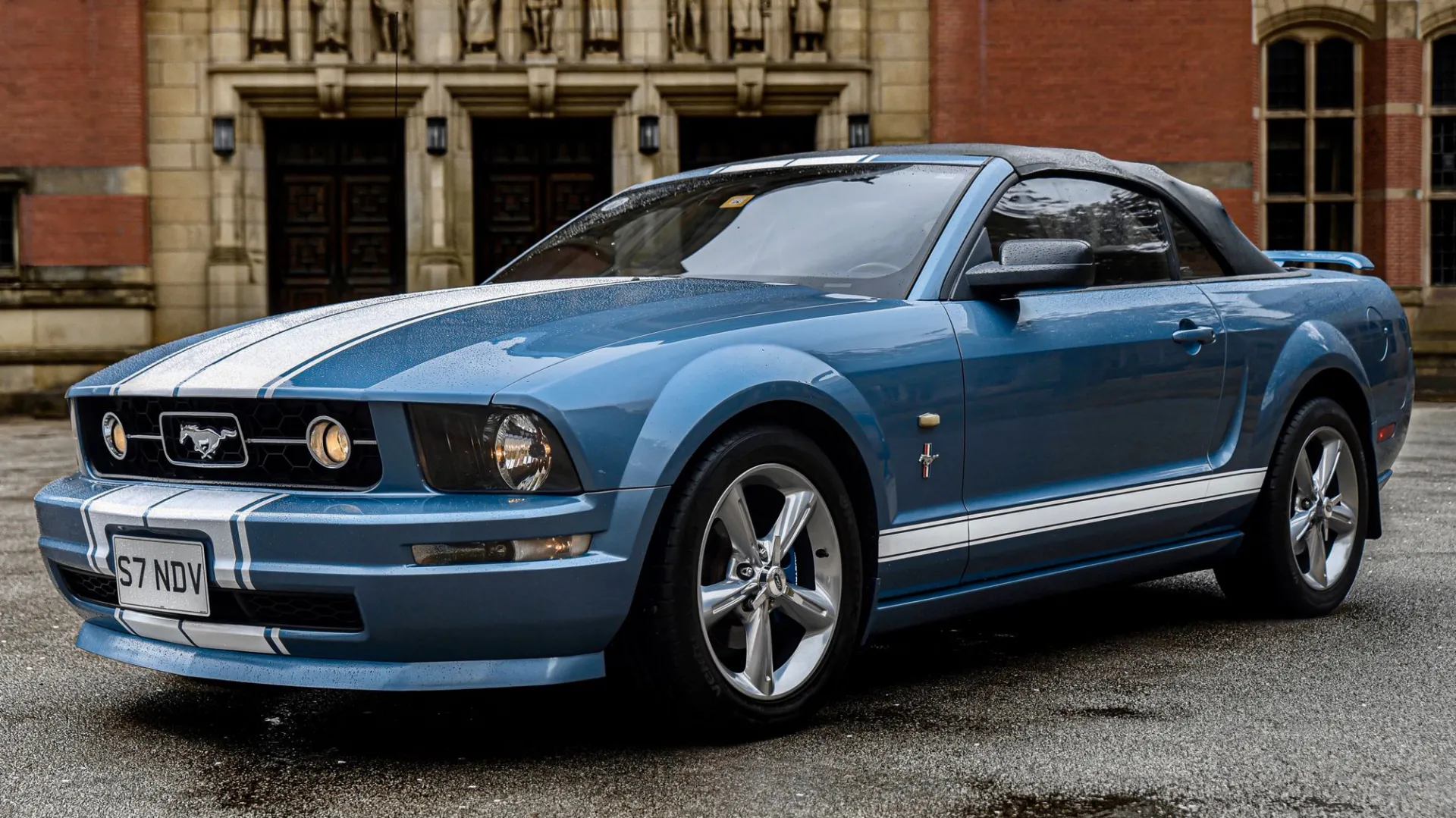 Front left side view of Blue Ford Mustang with convertible roof close.