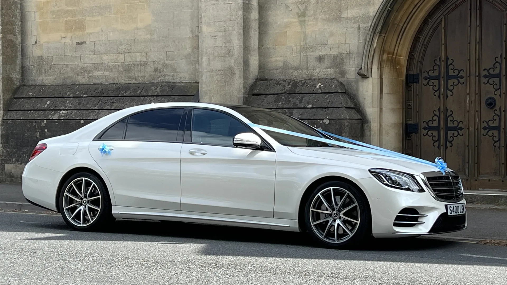 White Mercedes S400 LWB with white wedding ribbons