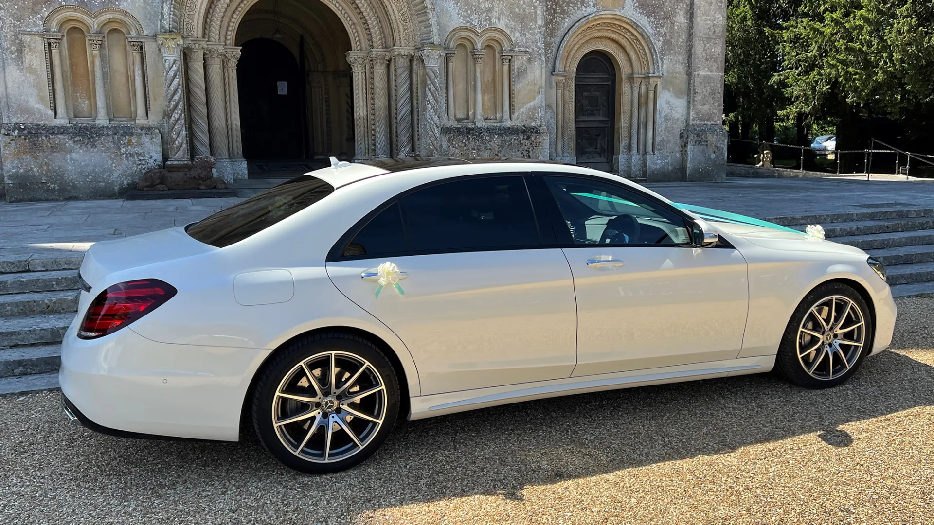 White Mercedes with rear tinted windows parked in front of a church in Dorset